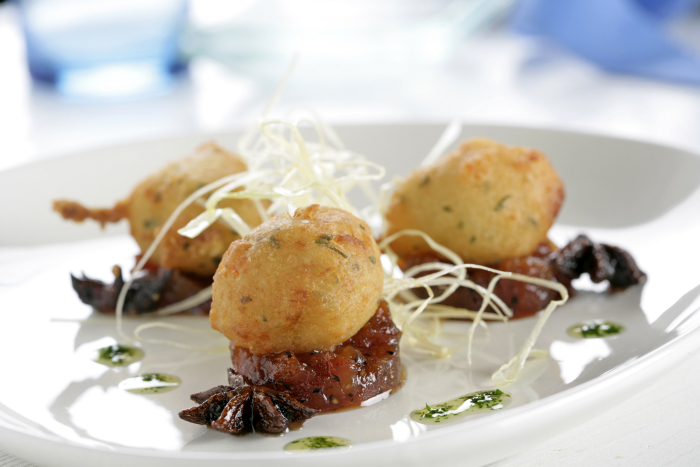 Buñuelo de merluza con gambas con compota de tomate, aceite de perejil y crujiente de puerro
